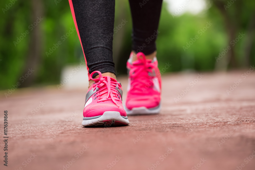 Fitness woman training and jogging in summer park, close up on r