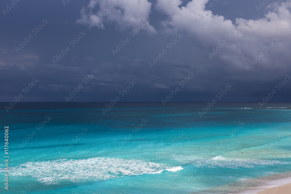 Stormy weather, beautiful turquoise sea under dark blue clouds,