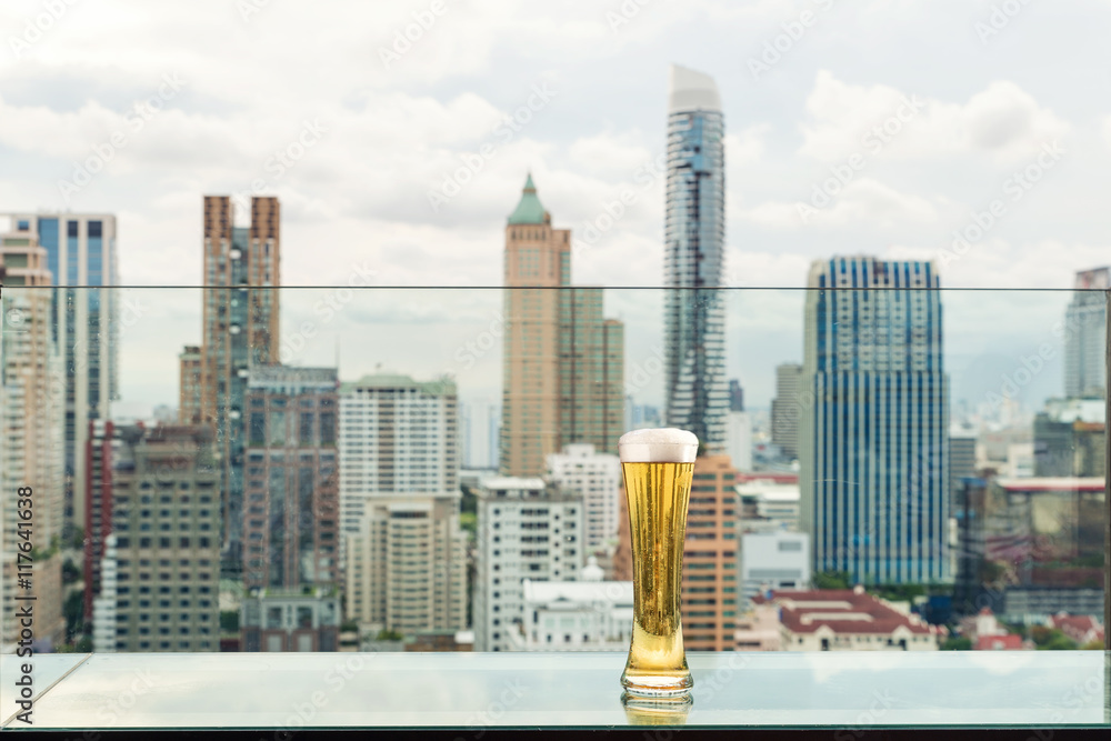 Beer and foam beer on table in rooftop bar in Bangkok, Thailand.