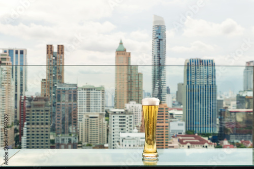 Beer and foam beer on table in rooftop bar in Bangkok, Thailand.