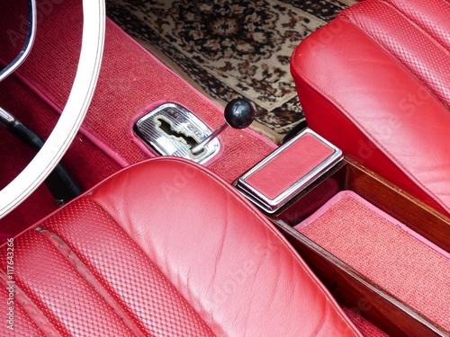 Obraz na plátně Rotes Interieur mit Leder, Aschenbecher und verchromter Schaltkulisse eines alte