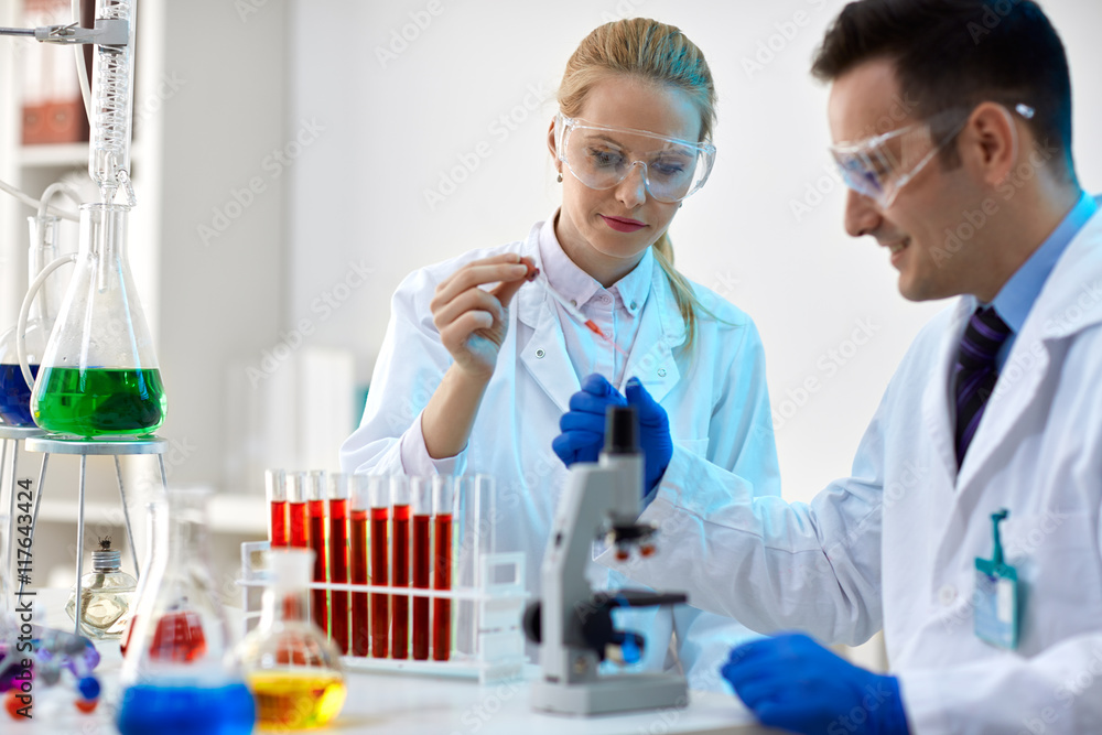 Two young scientists making an experiment in a laboratory. Two young scientists making an experiment in a laboratory.