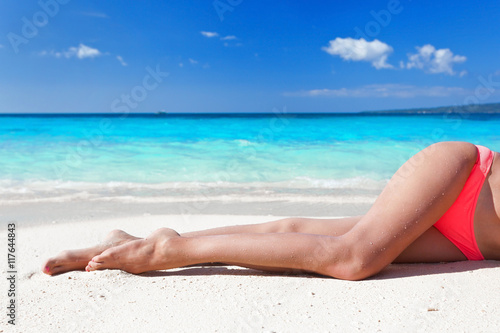 Tan slim legs on beach