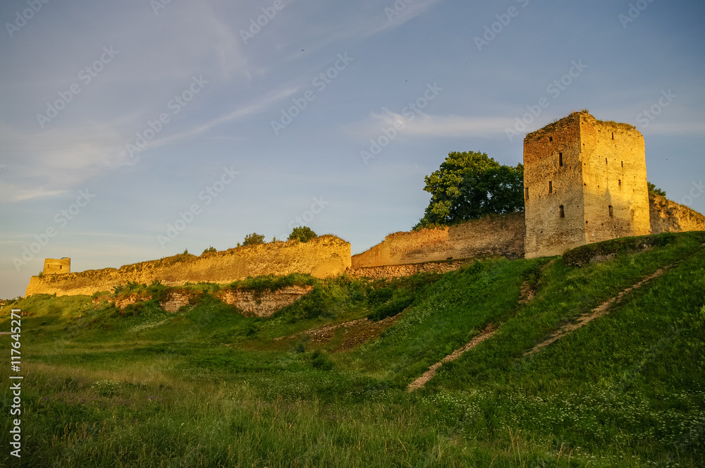 A view of the medieval Izborsk fortress walls and towers in sunset, Pskov region,Russia A view of the medieval Izborsk fortress walls and towers in sunset, Pskov region,Russia