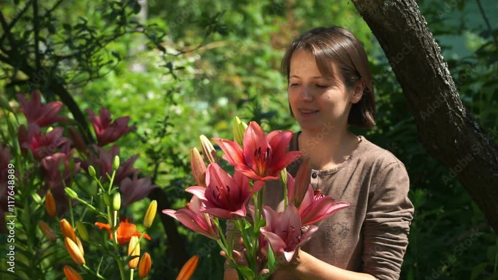 Pretty young woman smelling flowers in the garden and discovers his allergies Pretty young woman smelling flowers in the garden and discovers his allergies