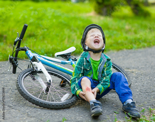 boy fell from the bike in a park photo