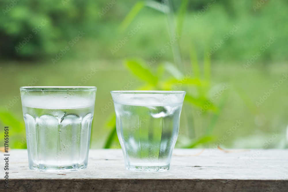 Cool water on wooden desk with Lake background Cool water on wooden desk with Lake background