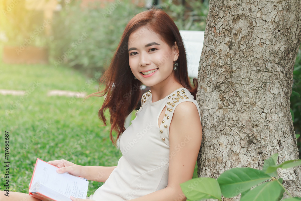 Asian woman reading a book in the garden for relaxation ,soft fo Asian woman reading a book in the garden for relaxation ,soft fo