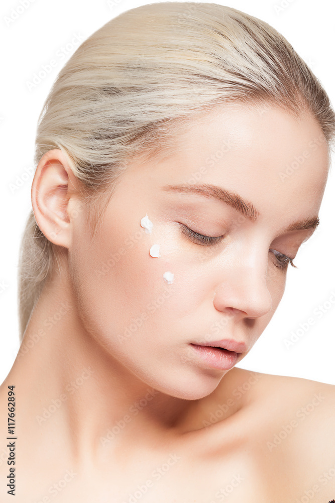 Woman with perfect skin and drops of cream on face