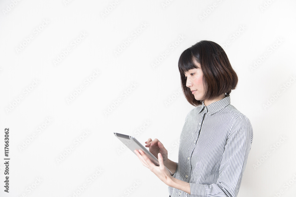 タブレットを触る女性・白バック タブレットを触る女性・白バック