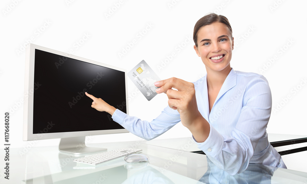 smiling woman with credit card in office at desk front of comput smiling woman with credit card in office at desk front of comput