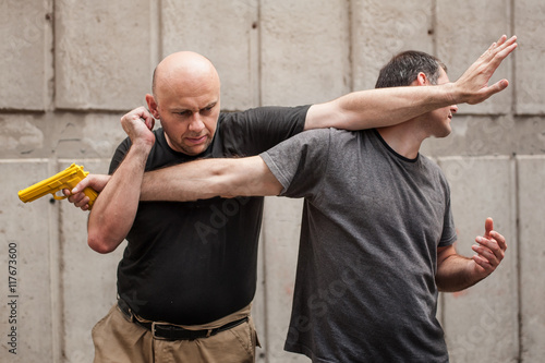 Kapap instructor demonstrates self defense techniques against a gun point. Gun Disarm.