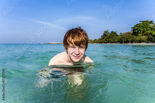 red haired boy enjoys the crystal clear water in the sea © travelview