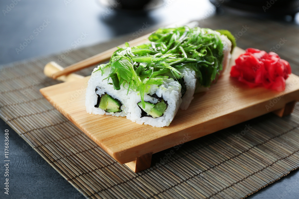 Sushi roll set and marinated ginger on wooden stand Sushi roll set and marinated ginger on wooden stand