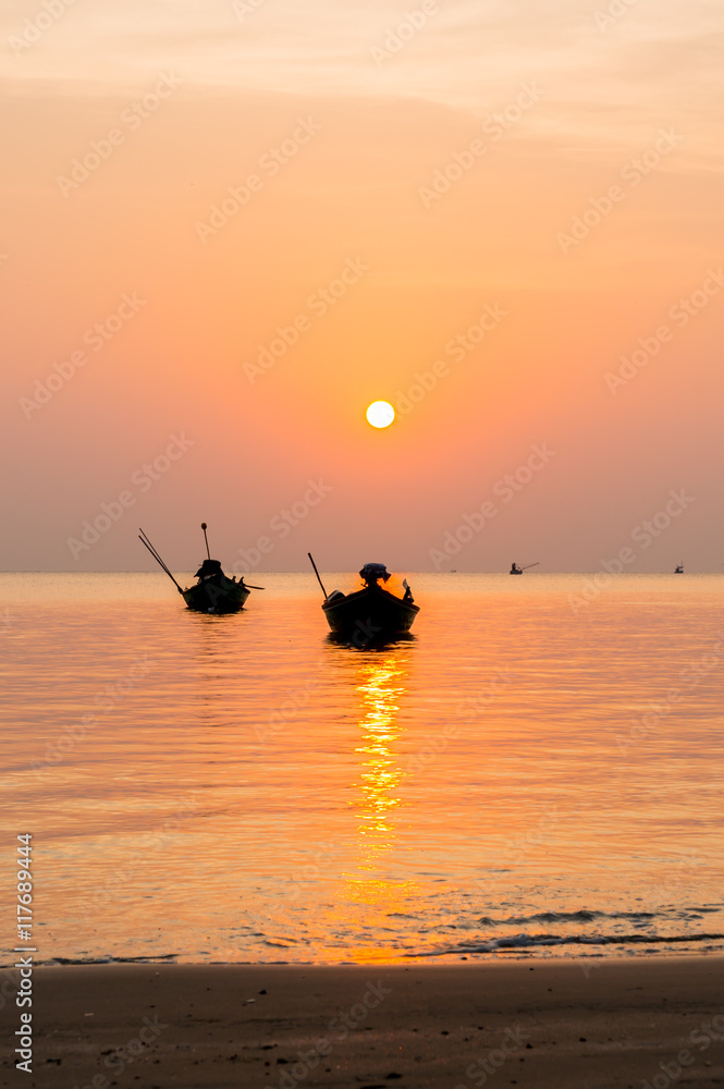 silhouette of Small fishing boats on the sea during sunrise