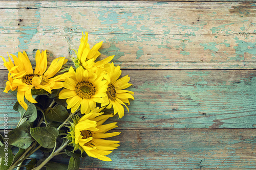 Background with a bouquet of sunflowers on old wooden boards wit