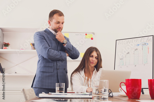 Valokuva Businessman supervising his female assistant's work on laptop computer