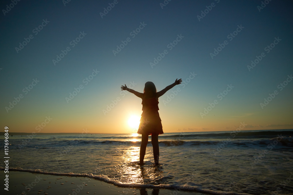 Fototapeta premium girl playing on the beach at sunset