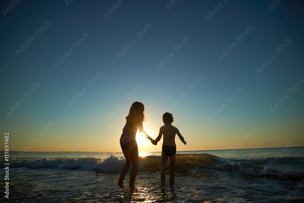 Fototapeta premium boy and girl on the sea at sunset