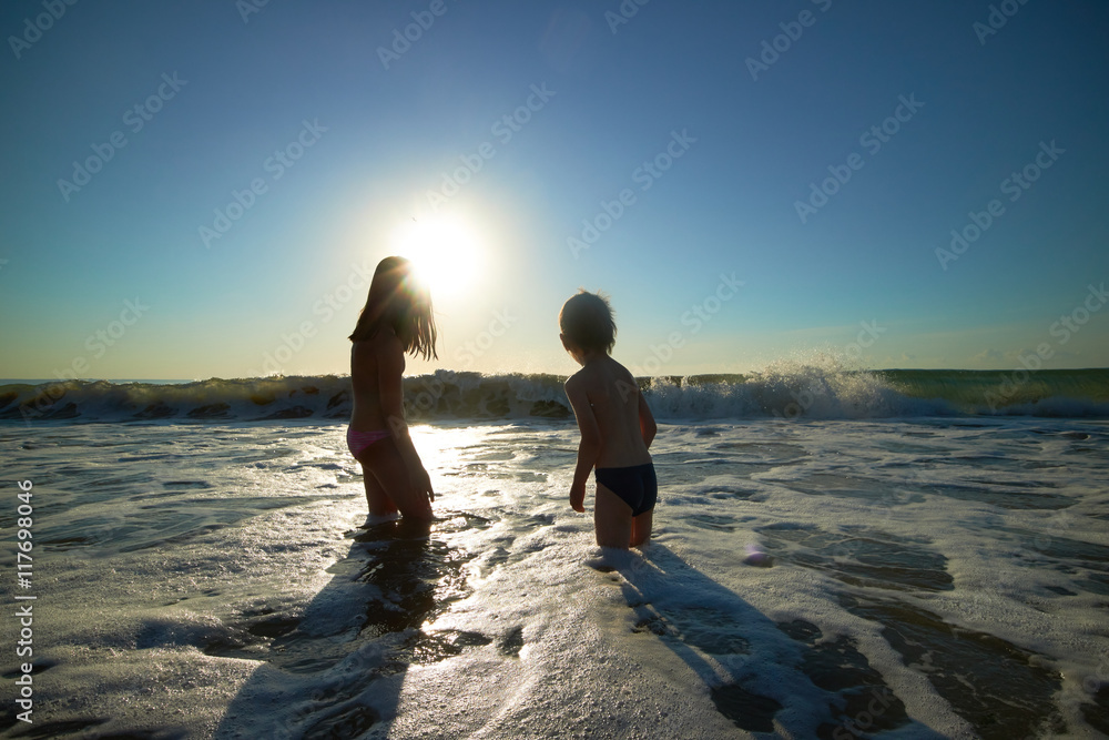 boy and girl on the sea at sunset boy and girl on the sea at sunset
