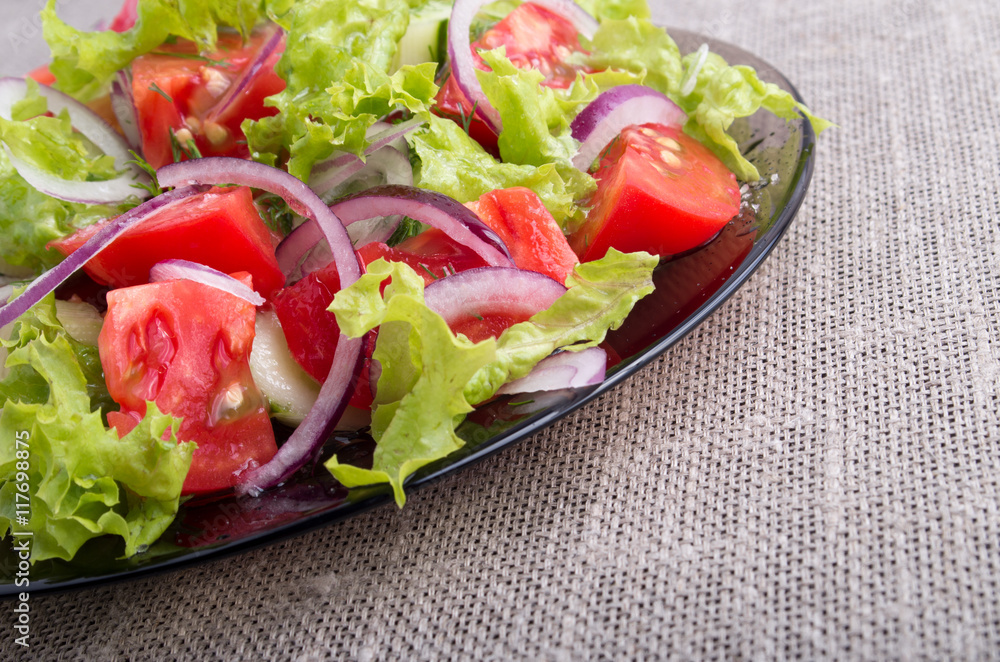 Side view on a diagonal on a plate with fresh salad of raw veget Side view on a diagonal on a plate with fresh salad of raw veget