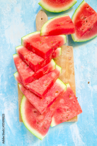 Watermelon slices on chopping board, top view