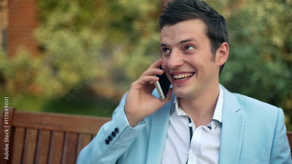 Young businessman talking on the phone in the park