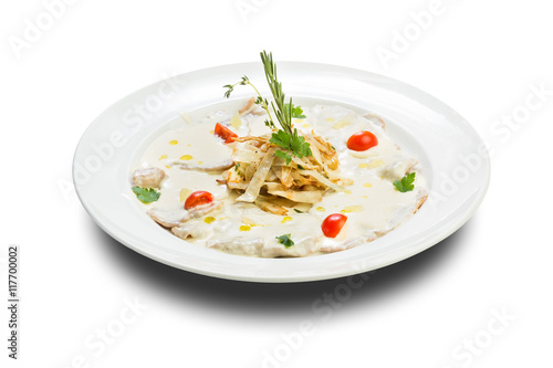 fish in a creamy sauce with fried onions and a sprig of green on a white plate and a white background