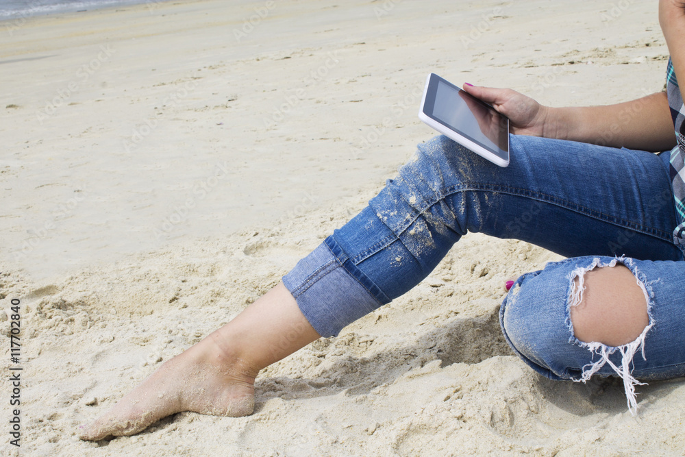 pretty girl using digital tablet on the beach pretty girl using digital tablet on the beach
