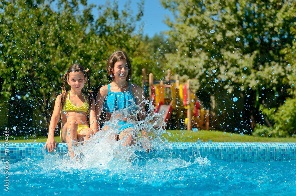 Kids in swimming pool have fun and splash in water, children on family vacation
