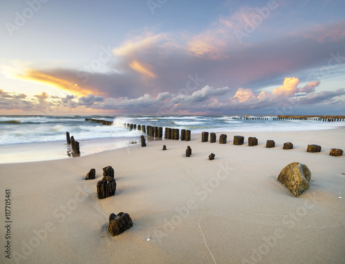 dynamic landscape of sea, the waves breaking on the breakwater, sunset on the sea beach
