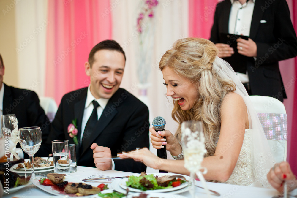 Laughing bride looks at her wedding ring sitting at the table Laughing bride looks at her wedding ring sitting at the table