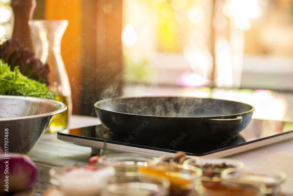 Steam from frying pan. Black portable cooker. Cooking tasty food requires mastery. What's for dinner. Steam from frying pan. Black portable cooker. Cooking tasty food requires mastery. What's for dinner.
