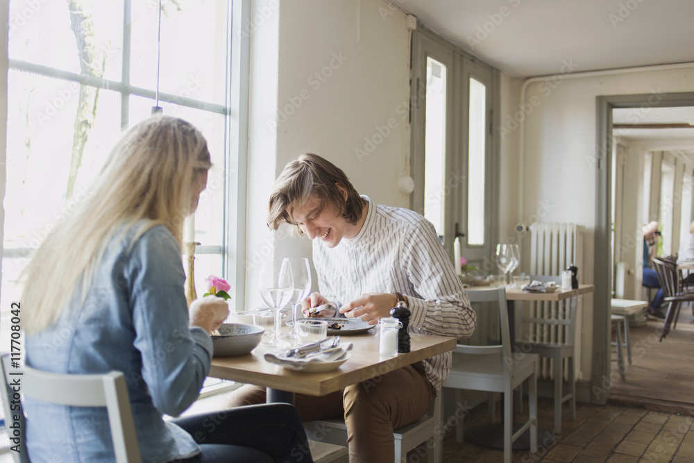 Happy male and female friends having food in restaurant Happy male and female friends having food in restaurant