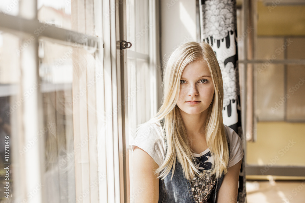Portrait of teenage girl sitting by window Portrait of teenage girl sitting by window