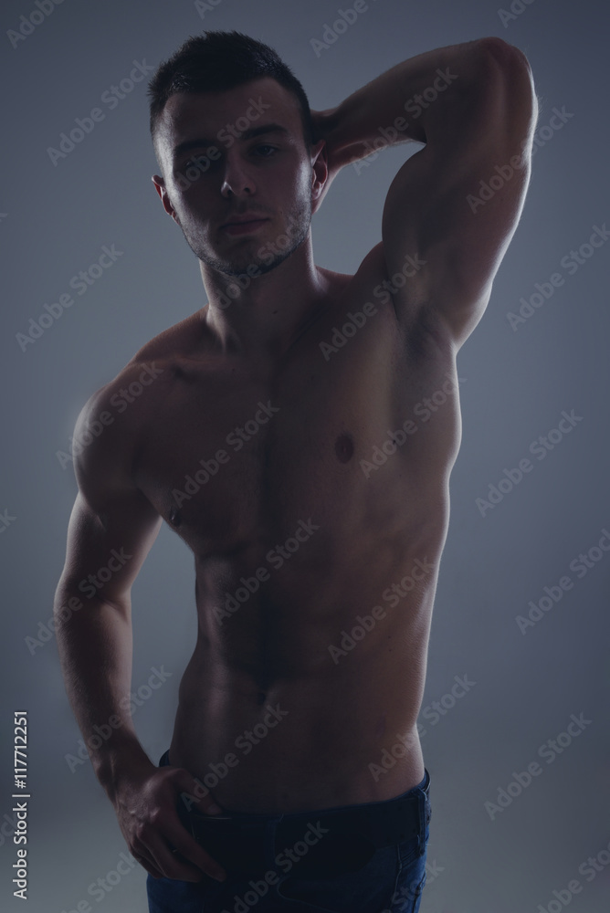 Young handsome guy posing in a studio with a beautiful body Young handsome guy posing in a studio with a beautiful body