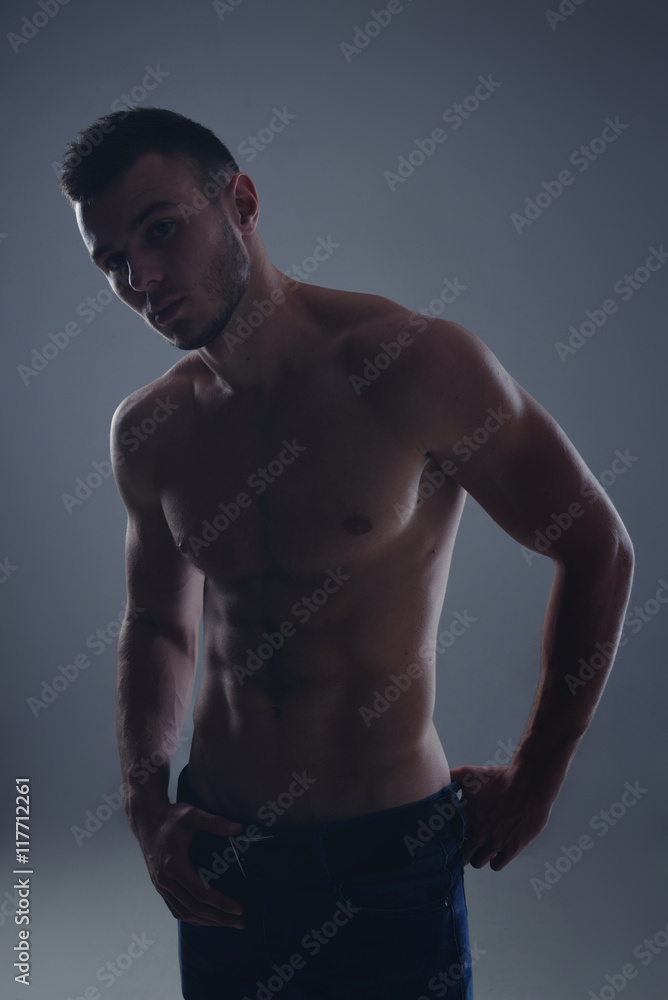 Young handsome guy posing in a studio with a beautiful body Young handsome guy posing in a studio with a beautiful body
