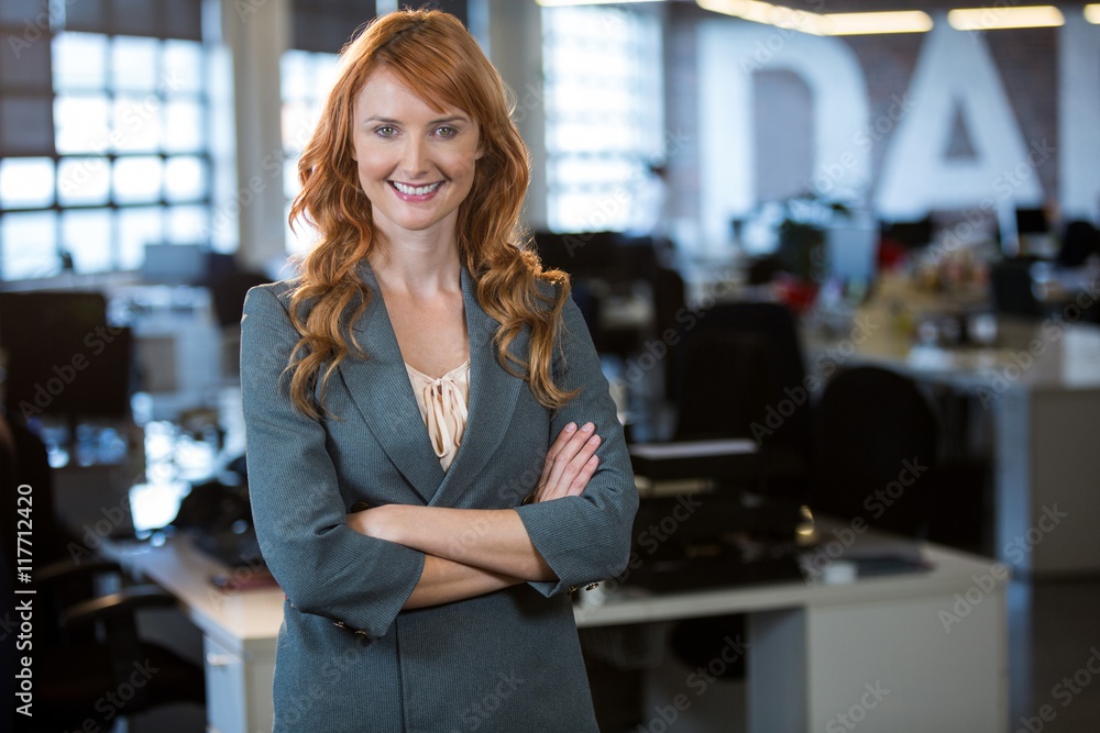 Confident businesswoman standing by desk Confident businesswoman standing by desk
