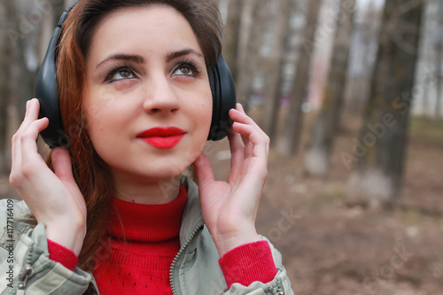 woman with headphones in park autumn photo