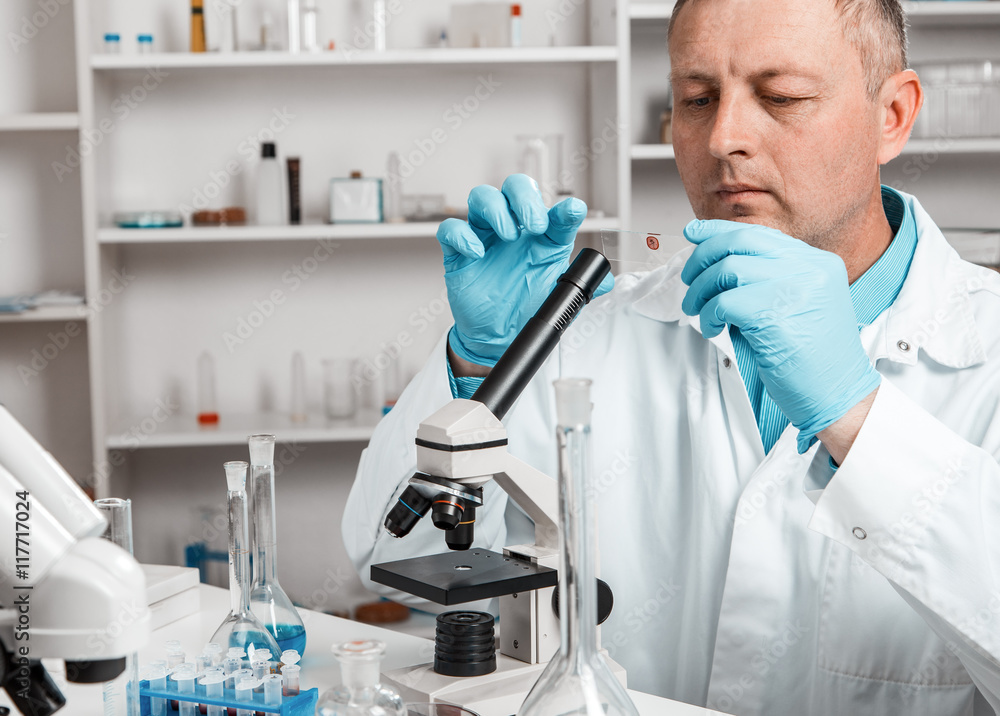 Fototapeta premium male scientific researcher using microscope in the laboratory.