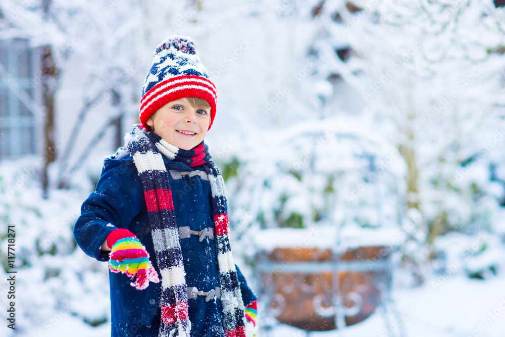 Happy kid boy having fun with snow in winter Happy kid boy having fun with snow in winter