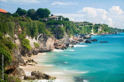 Scenic landscape of high cliff on tropical white sand Pantai beach in Bali, Indonesia photo