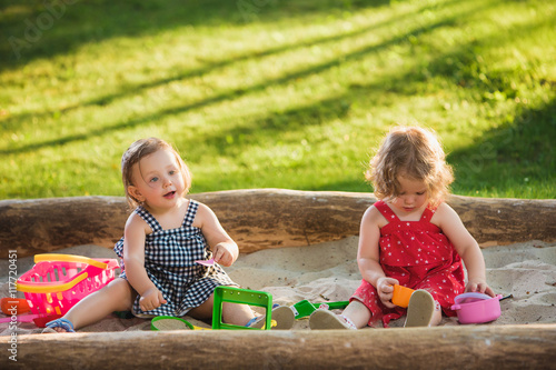 Foto The two little baby girls playing toys in sand