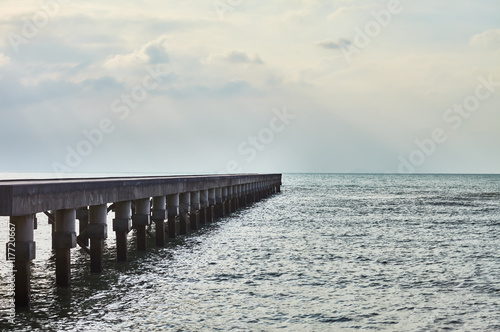  wooden pier with sun rays over sea
