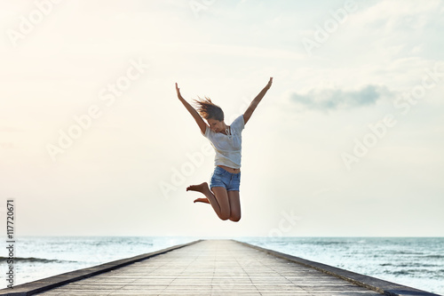Fotografia Happy jumping girl on the pier