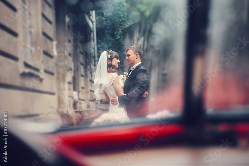 A view from the car on a wedding couple standing outside