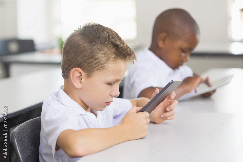 School kids using digital tablet in classroom School kids using digital tablet in classroom