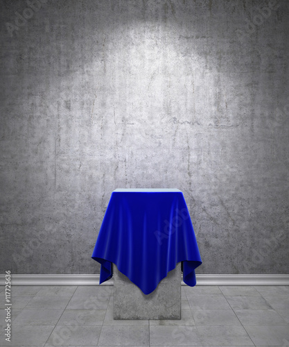 Presentation pedestal covered with a blue cloth in front on conc © sveta