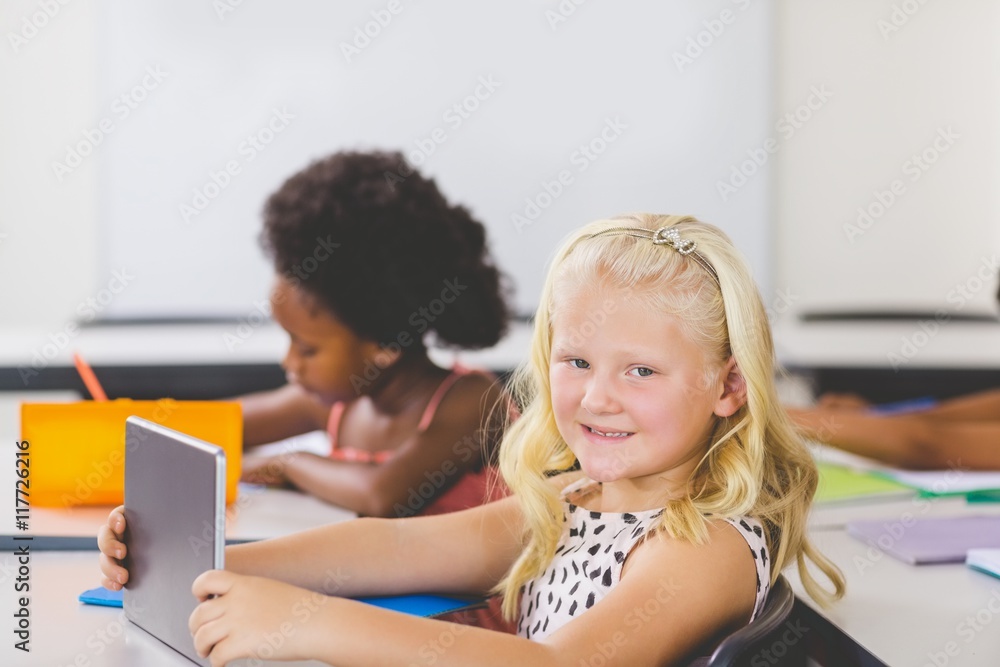 Schoolgirl using digital tablet in classroom Schoolgirl using digital tablet in classroom
