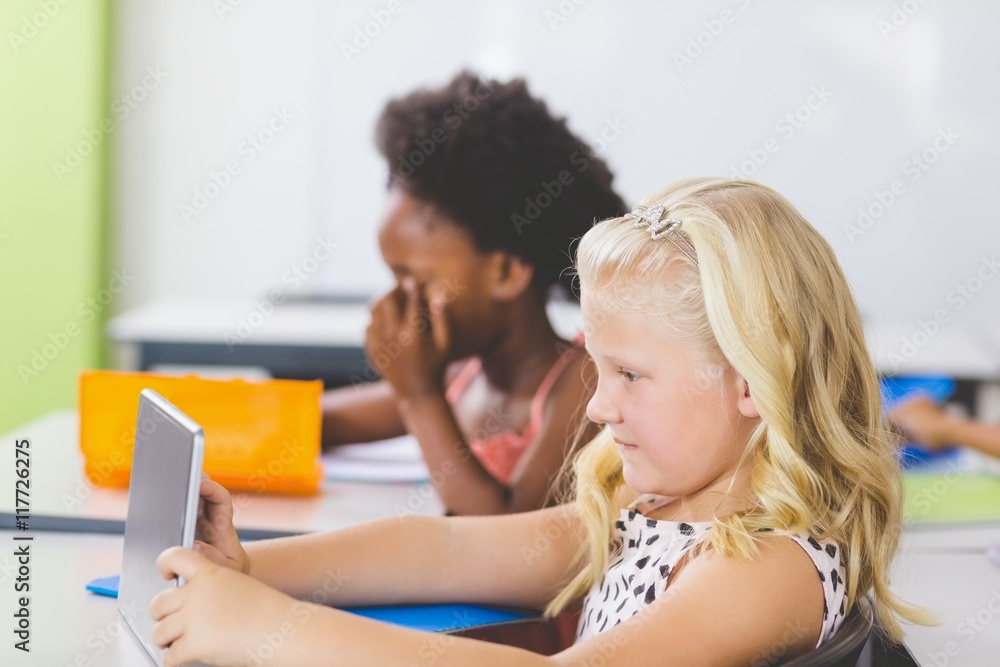 Schoolgirl using digital tablet in classroom Schoolgirl using digital tablet in classroom